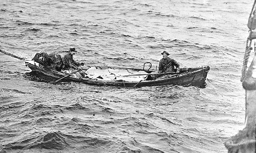The men approach the schooner with a full load of halibut.